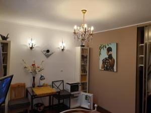 Una sala de estar con una mesa y una lámpara de araña. en REDHOUSE Chambre zen, en Roques Sur Garonne 13 fotos más