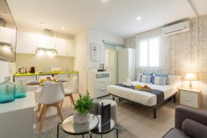 um pequeno quarto com uma cama e uma cozinha com uma mesa em Ronda de Valencia apartamento em Madri