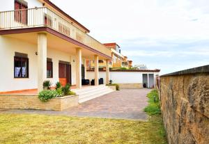 a house with a stone wall in front of it at Seafront apartment in Villa , near Rome in Torvaianica