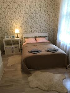a bedroom with a bed and a table with a lamp at Family house Jurmala in Jūrmala