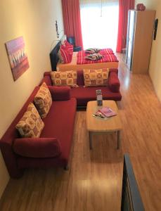エアフルトにあるAltstadt Ferienwohnungのリビングルーム(赤いソファ、テーブル付)
