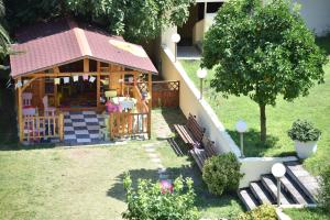 a small house with a playground in the yard at Palladium Hotel in Kriopigi