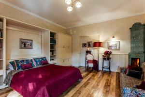 een slaapkamer met een bed, een bank en een open haard bij Studios at Anchevskih 3 in Lviv