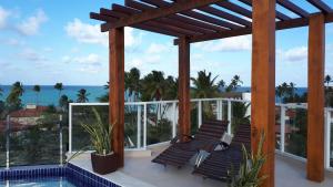 un balcon avec des chaises et une vue sur l'océan dans l'établissement Makaiba Residence 203, à Porto de Galinhas