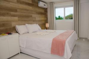 - une chambre avec un lit blanc et un mur en bois dans l'établissement Makaiba Residence 203, à Porto de Galinhas 25 autres photos