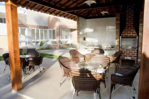 un patio extérieur avec des tables et des chaises et un bâtiment en briques dans l'établissement Makaiba Residence 203, à Porto de Galinhas
