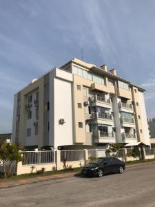 a black car parked in front of a building at Ed. Praia de Palmas SC in Governador Celso Ramos
