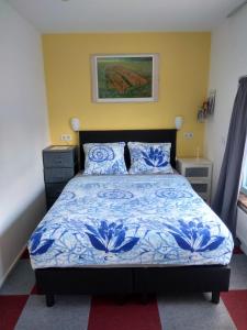een slaapkamer met een bed met blauwe en witte lakens bij Bed and Breakfast Amsterdam Holy Dove in Amsterdam