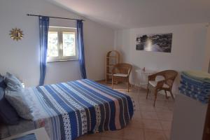 1 dormitorio con 1 cama y 1 mesa con sillas en Casa Maja, en Santa Maria di Castellabate