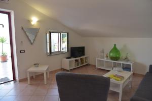 a living room with a couch and a tv at Casa Maja in Santa Maria di Castellabate