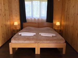 a bedroom with a bed with two towels on it at Guest House Keti Margiani Mestia in Mestia