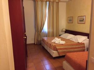a hotel room with two beds and a window at Hotel Delle Terme Santa Agnese in Bagno di Romagna