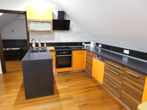 a kitchen with orange and black counters and cabinets at Apartmánový Penzión Bojnice in Bojnice