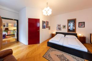 ein Schlafzimmer mit einem großen Bett und einer roten Tür in der Unterkunft Sixties Appartement in Graz