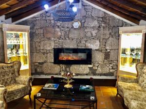 a living room with a stone wall with a fireplace at Hotel Rural Vilaflor Self Check In 24h in Vilaflor