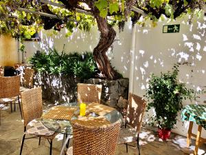 a table and chairs with a tree in a patio at Hotel Rural Vilaflor Self Check In 24h in Vilaflor