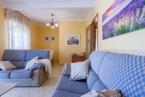 uma sala de estar com dois sofás azuis em Desconectaengalicia Casa Portonovo em Portonovo