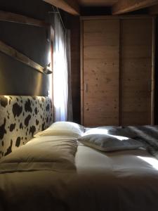 a dog laying on a bed in a room at LTHorses & Dreams in La Thuile