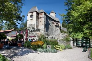 an old stone building with a flower garden in front of it at Schloss Matzen in Reith im Alpbachtal