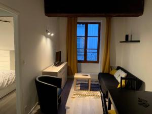 een woonkamer met een bank en een raam bij Porte Bourgogne in Orléans