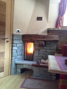 a fire place with a stone fireplace and a brick wall at LTHorses & Dreams in La Thuile