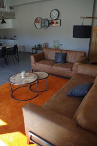 a living room with two couches and a table at Eco-gîte Au Natur'Ailes des Collines in Tournai