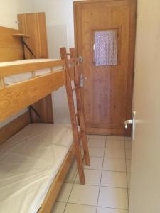 a room with two bunk beds and a door at La Belledone à Vaujany in Vaujany