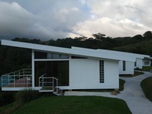 a large white house with a white roof at Hotel Laguna Arenal in Unión
