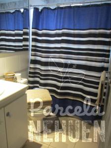 a bathroom with a shower with a blue and white shower curtain at Parcela 9 Nehuen in Talagante