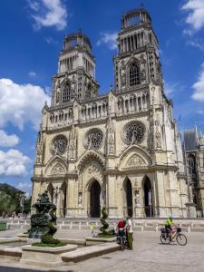 a large cathedral with people on bikes in front of it at Porte Bourgogne in Orléans