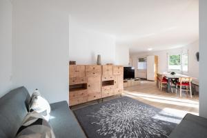 un soggiorno con divano e tavolo di Agrimonia - 5,5-Zi Duplex Wohnung bis 9 Personen mit eigenem Garten a Davos