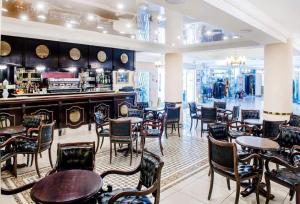 a restaurant with tables and chairs and a bar at Hôtel Christ Roi in Lourdes