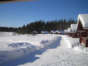 a snow covered yard with a group of houses at Korvala log cabins in Korvala