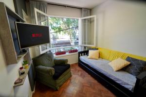 a living room with a couch and a tv and a chair at Mendoza Centro Aparment in Mendoza
