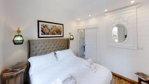 a white bedroom with a large white bed and a mirror at LoveTheRoof SpectacularTerrace&View - LoveTheApartments in Florence