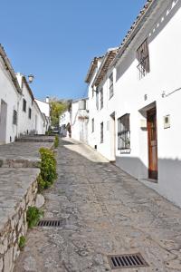 eine Kopfsteinpflasterstraße in einer Stadt mit weißen Gebäuden in der Unterkunft Casa El Simancón in Grazalema