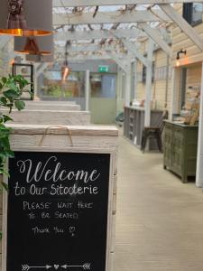 a sign in a store with a welcome to our storefront at Abbey Guest House in Peterhead