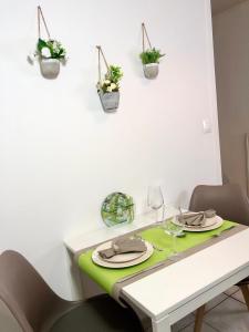 メスにあるL'appart des Tanneursのダイニングルームテーブル(緑と白のテーブルクロス付)