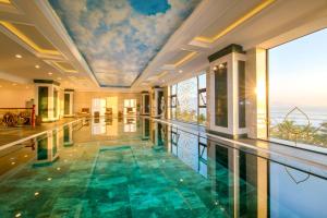 a swimming pool in a house with a painting on the ceiling at Eden Ocean View Hotel Da Nang in Da Nang