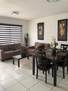 a living room with a couch and a table and chairs at Condo Vacational in Ensenada, B.C. in Ensenada