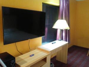 una camera con un grande televisore e un tavolo con una lampada di Ashburn Inn Of Manning a Manning