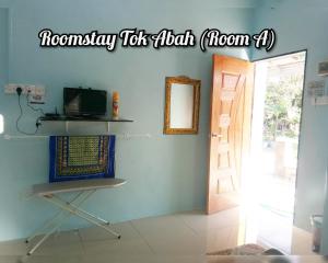 ein Zimmer mit einer Tür und einem Schild, das die Normalität zur Hälfte liest in der Unterkunft RoomStay Tok Abah A in Kuala Rompin