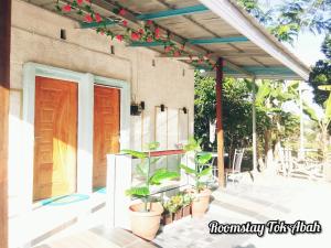 eine Terrasse mit Topfpflanzen und ein Gebäude in der Unterkunft RoomStay Tok Abah A in Kuala Rompin