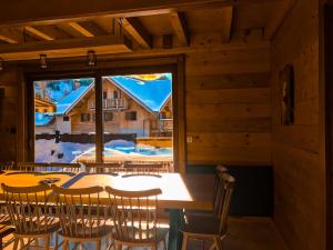 a dining room with a table and chairs and a window at Boost Your Immo Les Deux Alpes Chalet Gaspard 184 in Les Deux Alpes