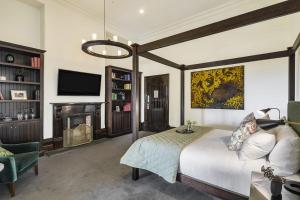 a living room with a bed and a television at Mount Lofty House in Adelaide