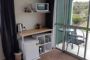 a room with a refrigerator and a table and a microwave at Clover Hill Studio Apartment in Milton