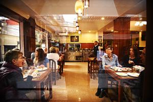 un gruppo di persone sedute ai tavoli di un ristorante di Hotel Friends Home a Kathmandu