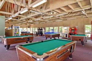 una sala de billar con 3 mesas de billar. en Williamsburg Camping Resort 38 ft. Park Model 5, en Croaker