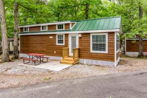 a small house with a picnic table in front of it at Williamsburg Camping Resort One Bedroom Loft Cabin 4 in Croaker