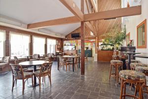 a restaurant with tables and chairs and windows at Williamsburg Camping Resort One Bedroom Loft Cabin 4 in Croaker